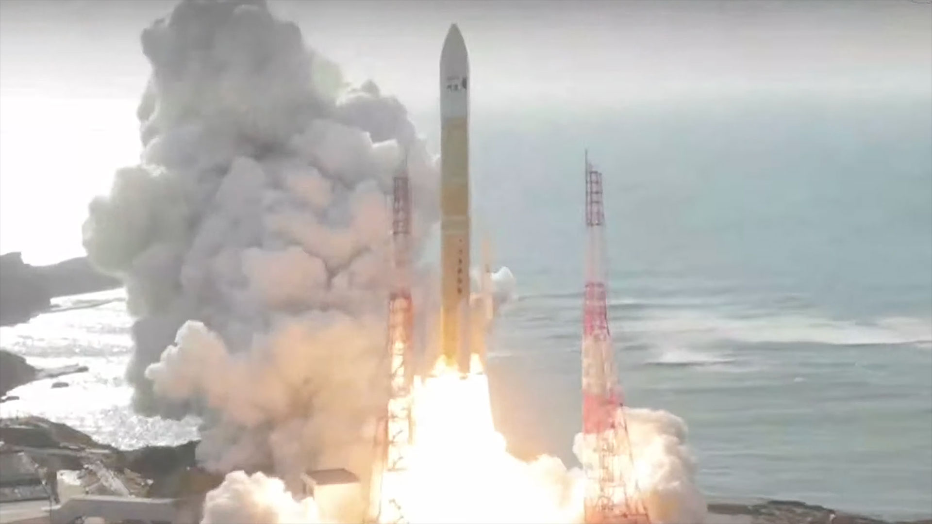 an orange and white rocket lifts off from its seaside launch pad